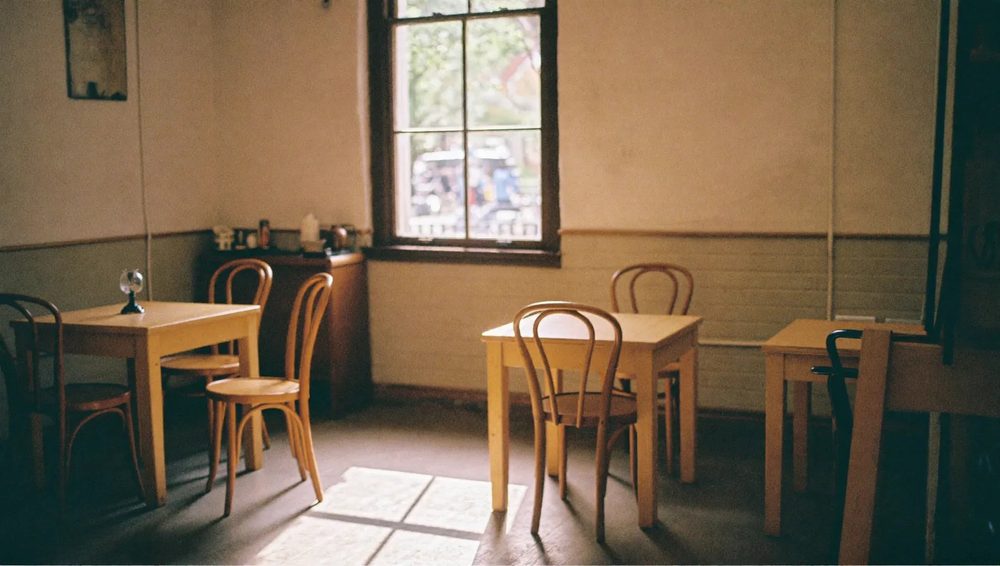 The room at The Grid Cafe: small wooden tables in warm daylight